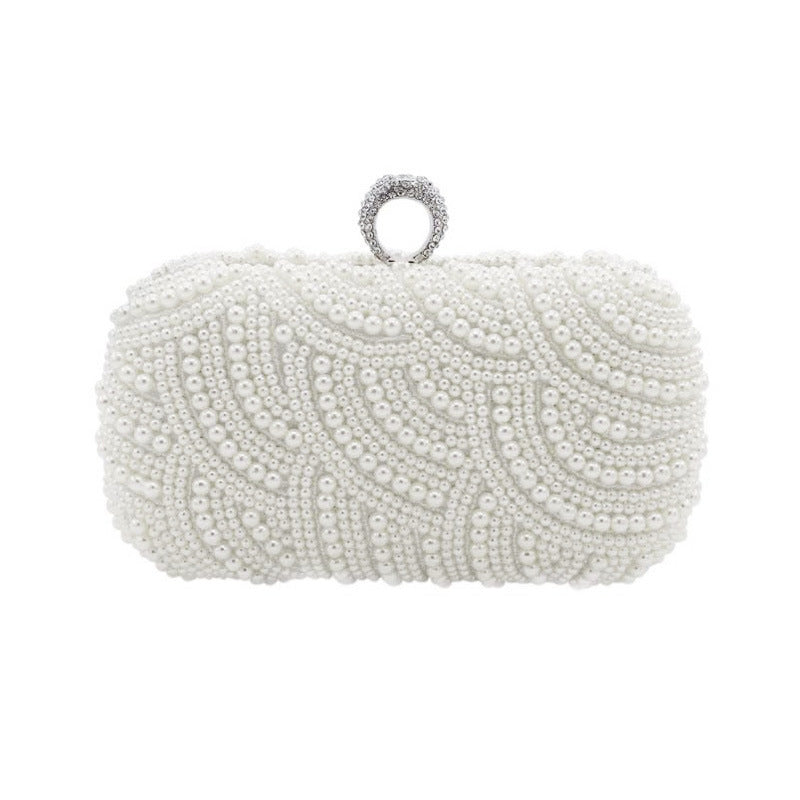 Rhinestone and Pearl Ringed Banquet Clutch Bag. Fully studded with pearls all over. The top clasp is adorned with a rhinestone ring to slip most fingers through as an extra way to securely hold your clutch bag. Comes in 2 colors. Beige and white,  Silver accents.