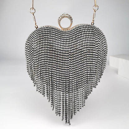 Pictured is the Black Heart Shaped Bag with Rhinestone tassel fringe hanging from the heart shape. Adorned with a rhinestone ring clasp big enough to stick most fingers through as as an additional way to hold the clutch. 6.69 inches * 7.87 inches * 3.54 inches in imperial measurements.