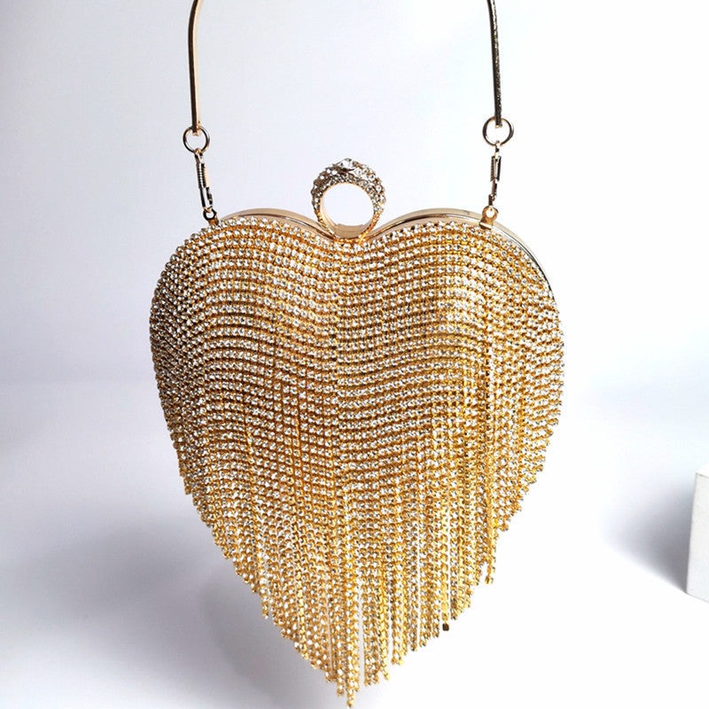 Pictured is the Gold Heart Shaped Bag with Rhinestone tassel fringe hanging from the heart shape.  Adorned with a rhinestone ring clasp big enough to stick most fingers through as as an additional way to hold the clutch.  6.69 inches * 7.87 inches * 3.54 inches in imperial measurements.